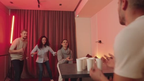 Amigos se divertindo jogando Beer Pong em uma festa em casa