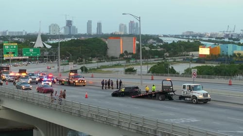 Une dépanneuse charge une voiture accidentée sur le lieu de l'accident Le personnel des services d'urgence répond au véhicule