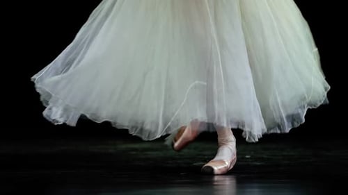 Elegant Woman in a White Tutu Dance Ballet and Balancing in Pointe Shoes View of the Legs Dark