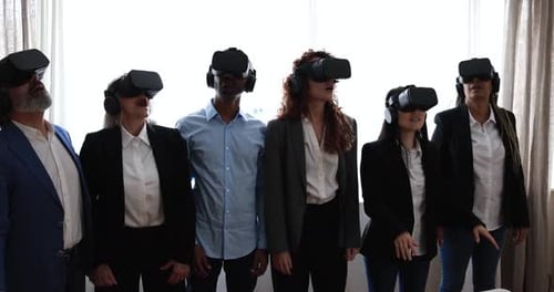 Multiracial teamwork having fun wearing virtual reality headset inside coworking office