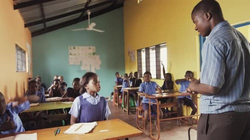 Front View of African Pupils / Students Raising Hand in Class