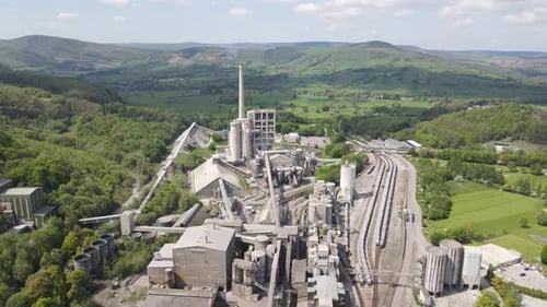 Vuelo aéreo con un dron sobre la fábrica de cemento Breedon Hope con vistas al Peak District circundante.