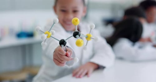 Smiling Child Holding Molecule Model in Science Lab