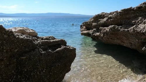 Unspoiled hidden paradise beach cove, woman swimming in background, Mediterranean