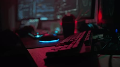 Workspace at Night with Keyboard and Computer Screens