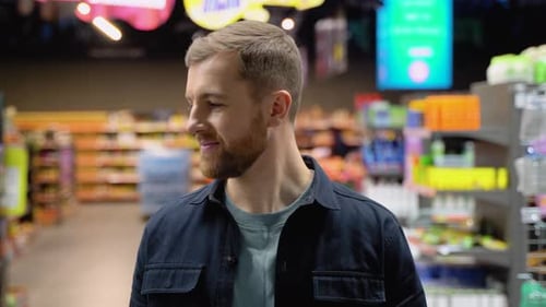 Caucasian Man Walks at Grocery Supermarket and Choosing the Right Product