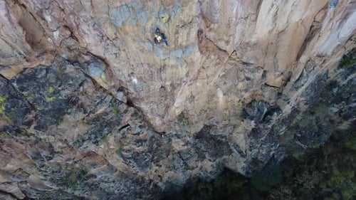Rock Climber Ascends Steep Cliffside Aerial View