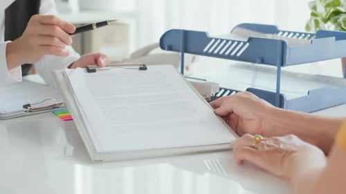 Asian Female Insurance Agent Offering Insurance Policy to Client