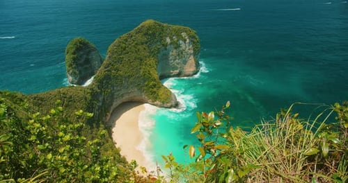 Sonniger Blick auf die Klippen von Kelingking Beach und das leuchtend türkisfarbene Meer Nusa Penida