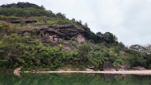 Uma colina verde pitoresca e exuberante que se reflete lindamente na superfície da água calma e serena
