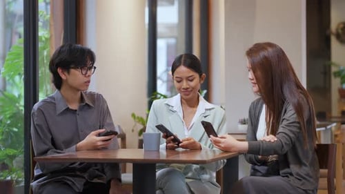 Asian professionals sitting together at a cafe table