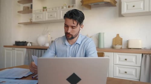 Bearded Man Working on Laptop in Kitchen