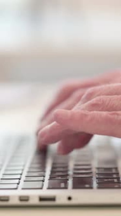 Hands Typing on Laptop Keyboard in Close-Up View