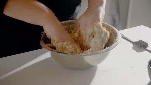 Young Female mixing water an flour making dough for a cake in the kitchen at home. Homemade pastry c
