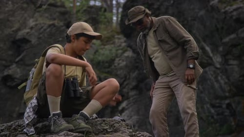 Hikers Study a Map on Rocky Outcrop