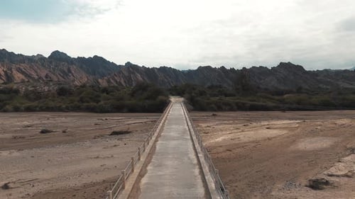 Drone flight over a narrow bridge crossing the Cachalqui River in the Quebradas de las Flechas, Salt