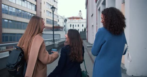 Three Friends Strolling Down City Sidewalk