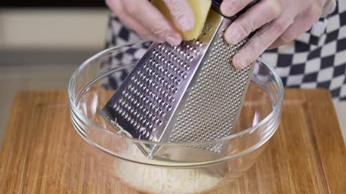 Grating Parmesan Cheese Into a Glass Bowl