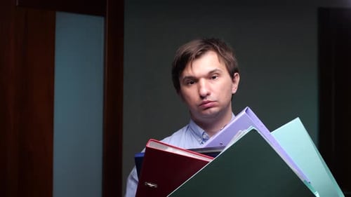 Office Worker Struggling with Stack of Binders and Files