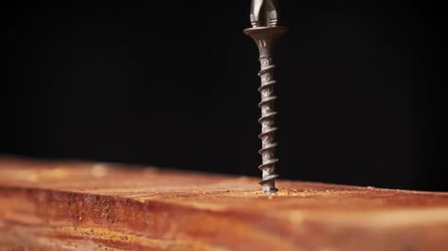 The Screw is Screwed Into the Wood Board with a Screwdriver Extreme Macro