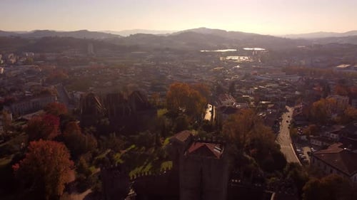 Medieval castle building and cityscape of Guimaraes city in Portugal, aerial drone shot during sunse