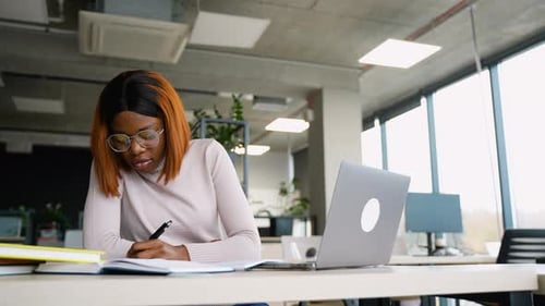 Woman Working in an Office Taking Notes