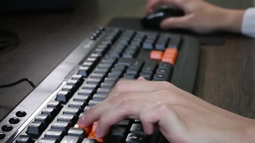 Spielen am Computer mit Maus und Tastatur. Nahaufnahme von der Seite, Fokus auf links