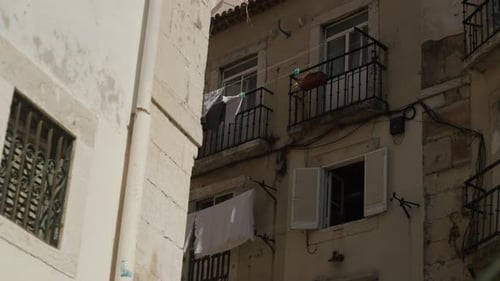Old Apartment Building With Balconies And Shutters In Lisbon, Portugal. Low Angle Shot