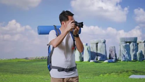 Young Man Photographs Stonehenge On A Sunny Day