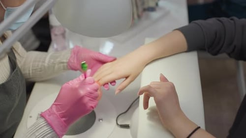 Manicurist Cleaning Fingernails With a Brush