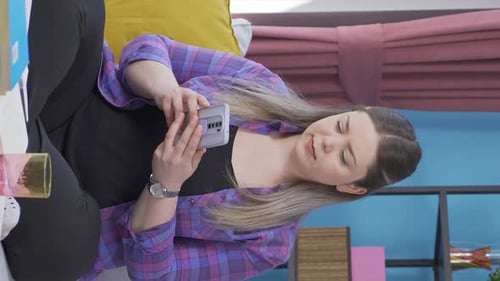 Woman Laughs While Watching Phone at Home