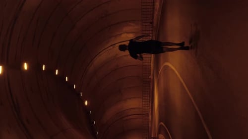 Man jogging alone in empty car tunnel. Male running in tunnel. Vertical video