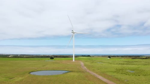 Aerial View. Beautiful windmill turbine, wind energy. Green field drone shot. 4k