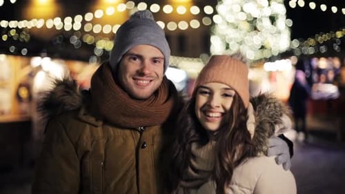 Happy young couple smiling at Christmas market