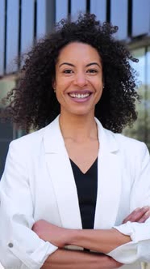 Confident Businesswoman Smiling in Front of Office Building