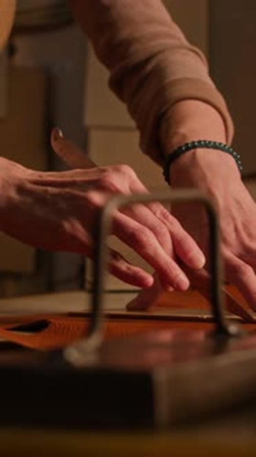 Vertical of Concentrated Craftswoman at Work in Leather Workshop