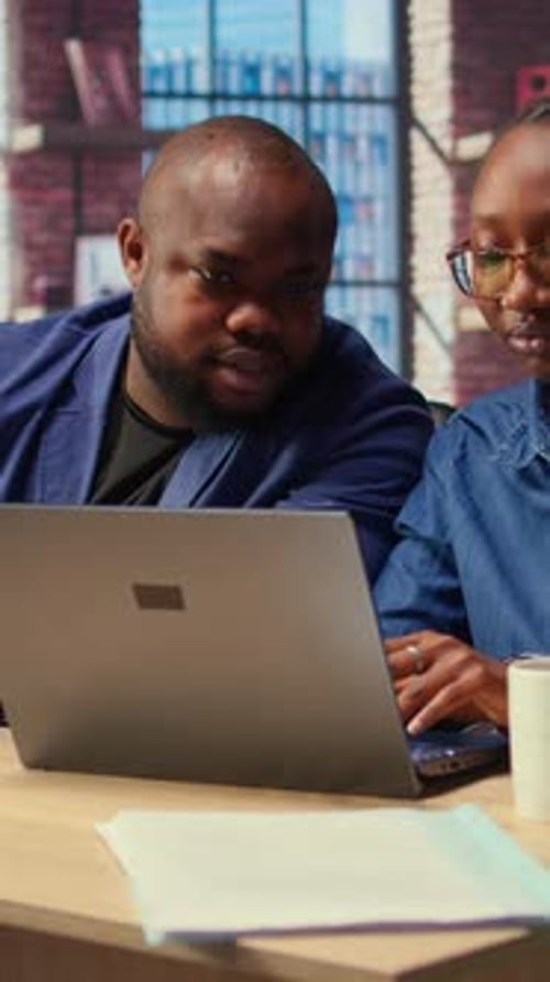 Partenaires de vie afro-américains travaillant à distance dans leur loft confortable