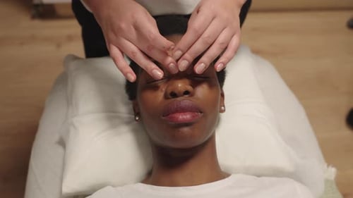 Relaxed Woman Receiving Facial Massage at Home