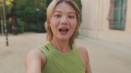 Smiling Woman Waving in an Urban Setting