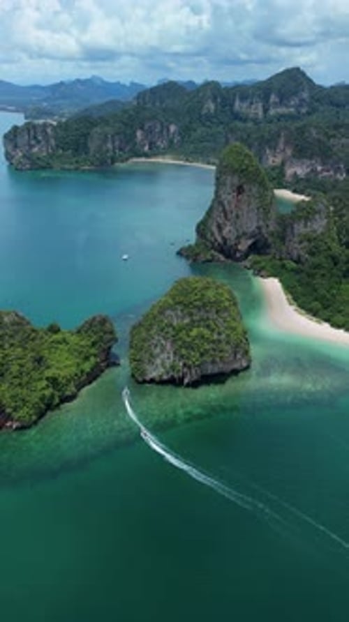 Vertical aerial orbit of speedboat by Ko Rang Nok and Phra Nang Beach, Krabi