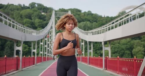 Sporty African American Woman Looking at Her Sport Bracelet on Hand Checking Data on Fitness Tracker