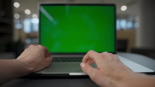 Unknown woman scrolls touchpad at chroma key laptop working online