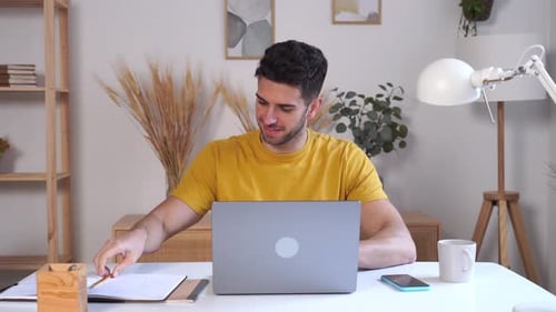 Man Working on Laptop at Desk at Home