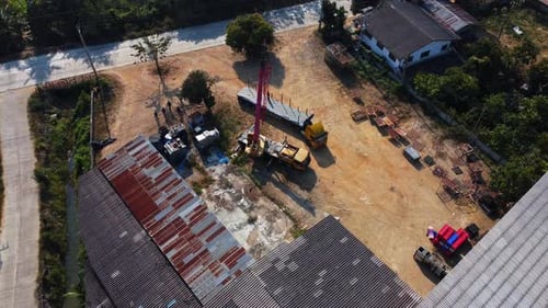 Mobile crane stands waiting to lift steel at a warehouse. Crane operators and mobile cranes