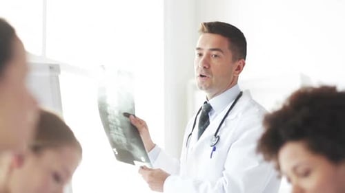 Doctor and interns discussing spine x ray at hospital medical education seminar