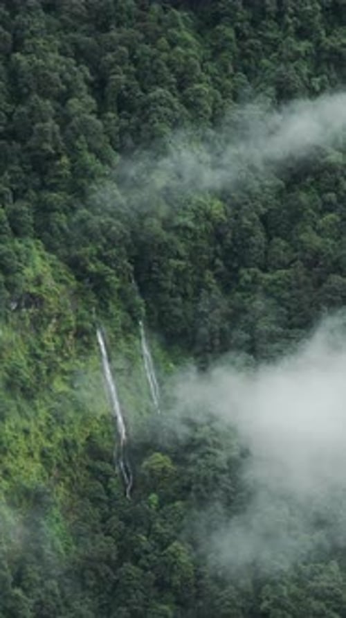 Vertical Mountains Waterfall in Clouds with Beautiful Green Forest of Trees, Vertical Video for Soci