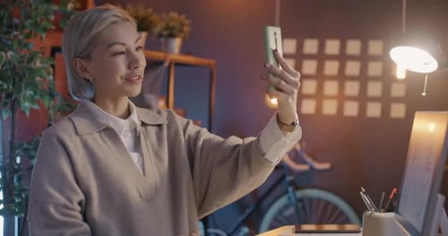 Young Adult Chatting on Smartphone at Desk