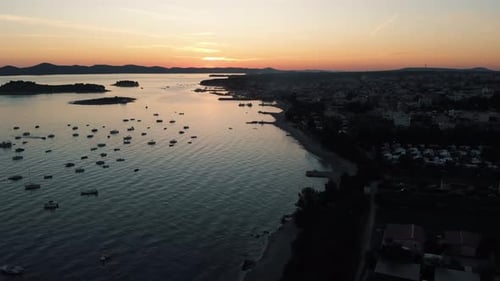 Panoramic landscape with boats in marina bay, sea, city lights, mountains, blue sky at dusk. Top vie