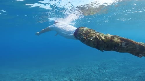 Man with Military Trousers Swims in the Sea
