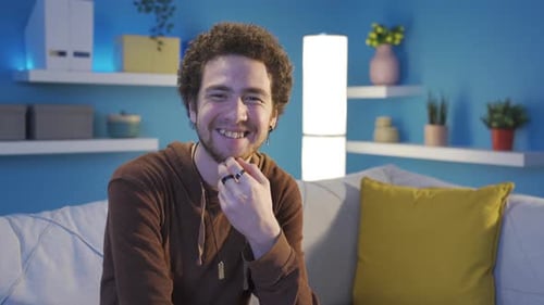 Fröhlicher und angenehmer junger Mann, der lächelt und Spaß daran hat, in die Kamera zu schauen.